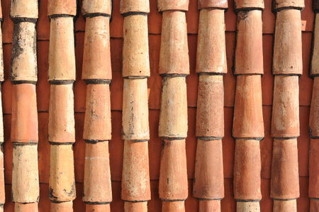 Red and orange roof tiles texture pattern on an old historical roof of a buildingの写真素材