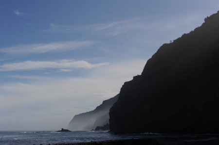 Rocky coast of Atlantic Ocean with mountains and cliffs and blue sky on Madeira Island, Portugalの写真素材