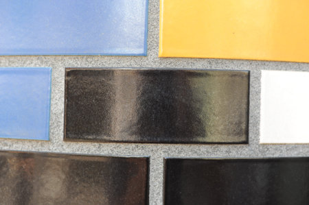 Ceramic tiles mosaic on a wall. Closeup photo of decorative, vintage, artistic tiles creating a...