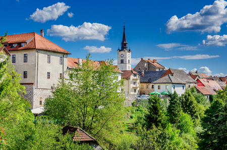 Photo for Townscape with castle and catholic church steeple. Crnomelj, Bela Krajina province, Slovenia. - Royalty Free Image