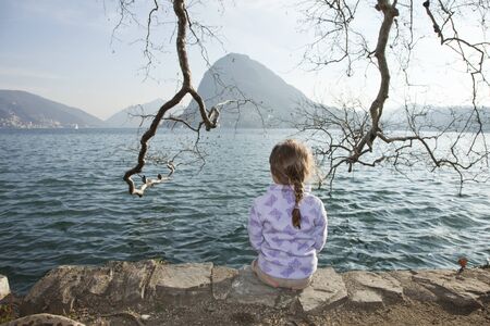 portrait little girl sitting in a lakeの写真素材