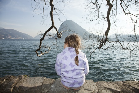 portrait little girl sitting in a lakeの写真素材