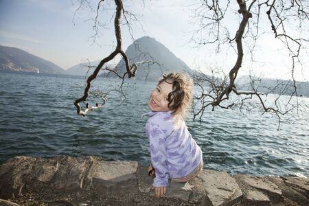 portrait little girl sitting in a lakeの写真素材