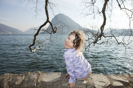 portrait little girl sitting in a lakeの写真素材