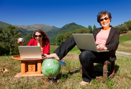 Businesswoman with computer in the parkの写真素材