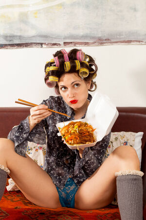 sexy girl eating spaghetti on the couchの写真素材
