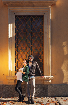Pregnant couple posing in front of the window of an old villaの写真素材