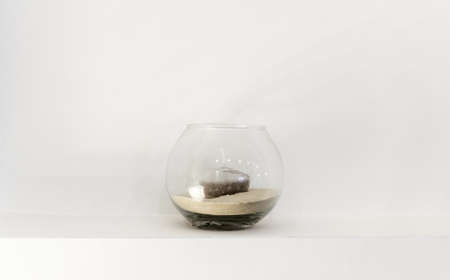 glass vase with a candle on white wallの写真素材