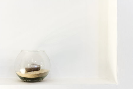 glass vase with a candle on white wall