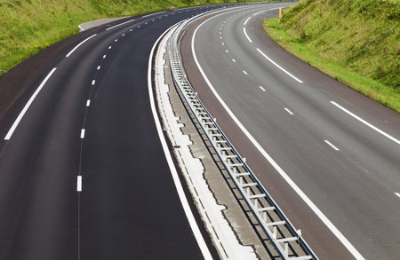 asphalt road through the green field