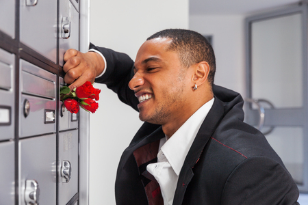 Lover boy puts roses in the letter box of the belovedの写真素材