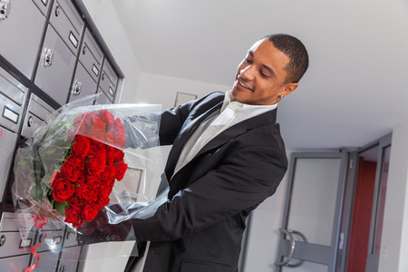 Lover boy puts roses in the letter box of the belovedの写真素材