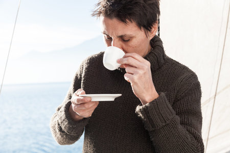 woman makes a coffee break aboard her sailboat