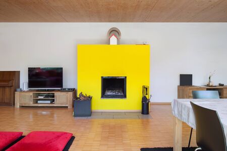 Interior of an eco house, living room with yellow fireplaceの写真素材