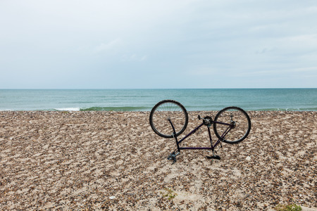 bike upside down on the beachの写真素材