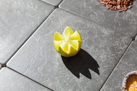 Closeup of a lemon section, gray tiles in background