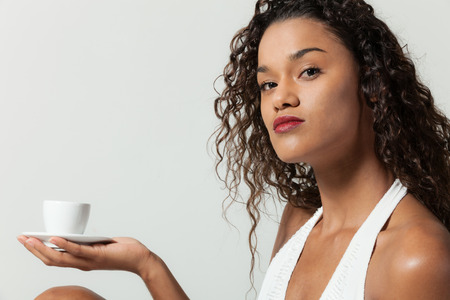 Beautiful girl with a cup of coffee,  portrait in studioの写真素材