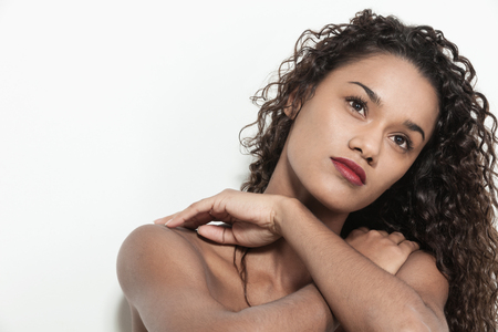 Young woman brazilian with curly hair posing in studio, closeupの写真素材