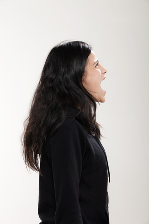 Portrait in studio of a girl wearing black sweatshirt, side viewの写真素材
