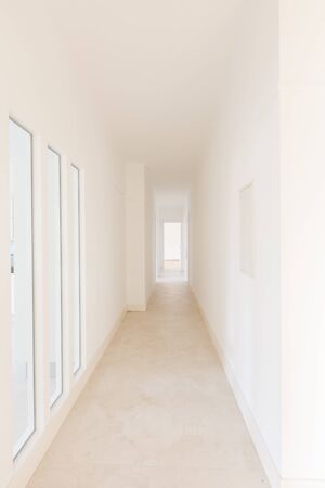 Empty long hallway with windows and doorsの写真素材