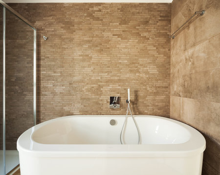 Modern white bathtub on a tiles background
