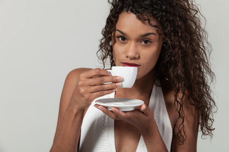 Beautiful girl with a cup of coffee,  portrait in studioの写真素材