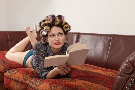 portrait of a model with a book, lying on the sofaの写真素材