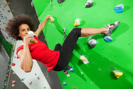 portrait of woman on artificial exercise climbing wall の写真素材