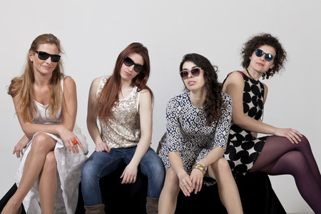 Four beautiful women pose together in the studioの写真素材