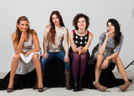 Four beautiful women pose together in the studioの写真素材