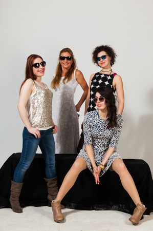 Four beautiful women pose together in the studioの写真素材