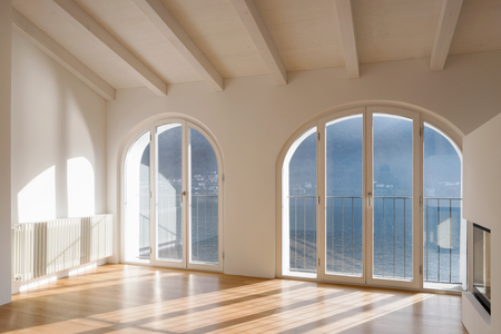 Empty room with large window overlooking the lake. Antique beams on the ceiling of a renovated apartmentの写真素材