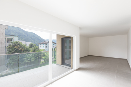 Large living room and completely white kitchen in a modern open space. Nobody insideの写真素材