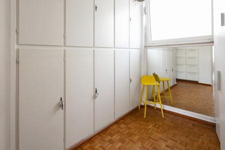 Room with white cabinets and a yellow stool. Nobody insideの写真素材