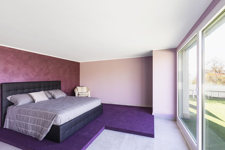 Bedroom overlooking the terrace with grass. Violet walls. Nobody insideの写真素材