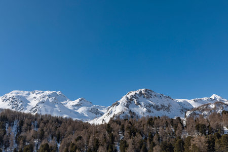 Detail of the snowy mountain top on Lukmanier on the Swiss Alps in Ticino. Blue sky