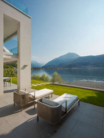 Detail of private terrace overlooking Lake Ceresio in Switzerland. Two deck chairs in the foreground. it's a sunny day and it's midsummerの写真素材