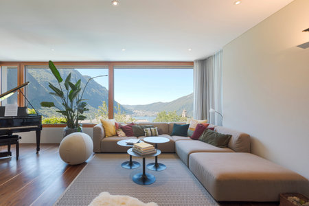 Front view of a living room with large, light-colored sofa and lots of pillows. Large window to the...