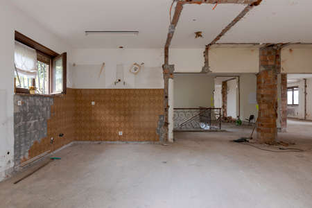 Large bright room with many windows of an old villa undergoing demolition and renovation. The walls have been knocked down and the floor is gone. Nobody insideの写真素材