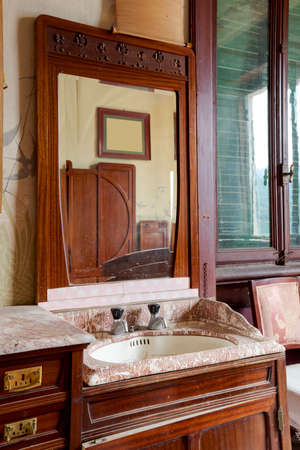 Detail old sink with mirror above in bedroom. Interior of an abandoned villa to be restored. Nobody insideの写真素材