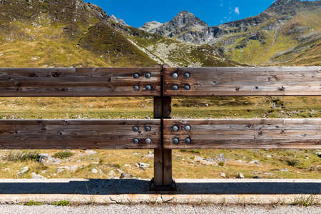 Front view of wooden fence to protect the road in alpine landscape. Spluga Pass, border between Italy and Switzerlandの写真素材