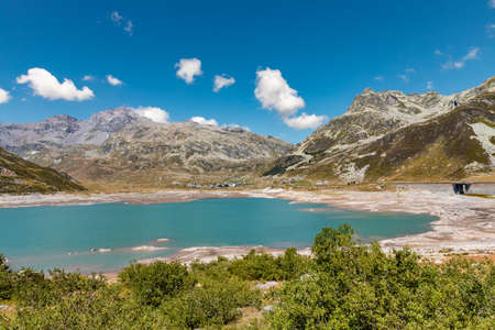 Panoramic view of Montespluga lake on a sunny summer day. The lake is nearly empty due to climate change. Spluga Pass, border between Italy and Switzerlandの写真素材