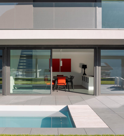 Exterior modern villa with swimming pool. Open windows and minimalist living room. Nobody insideの写真素材