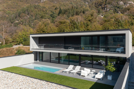 Exterior modern villa with swimming pool. The house is surrounded by mountains. Nobody insideの写真素材