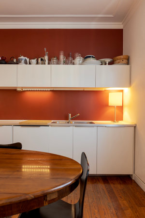 Elegant kitchen with red backsplash and white walls. Antique apartment interior with modern furniture. Nobody insideの写真素材