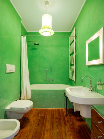 Bathroom with parquet floors and green walls, bathtub with shower and white curtain. Interior vintage apartment with modern furniture. Nobody insideの写真素材