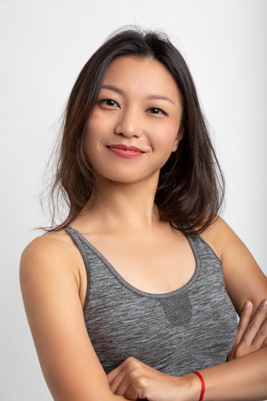 Portrait beautiful Asian girl with big smile and brown hair. Sportswear and lipstick. White backgroundの写真素材