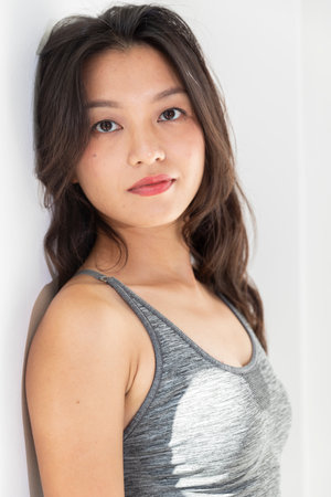 Portrait beautiful Asian girl with big smile and brown hair. Sportswear and lipstick. White backgroundの写真素材