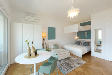 Studio with one double bed, one single bed. There is also a small white kitchen. Nobody insideの写真素材
