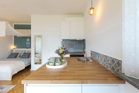 Studio with one double bed, one single bed. There is also a small white kitchen. Nobody insideの写真素材